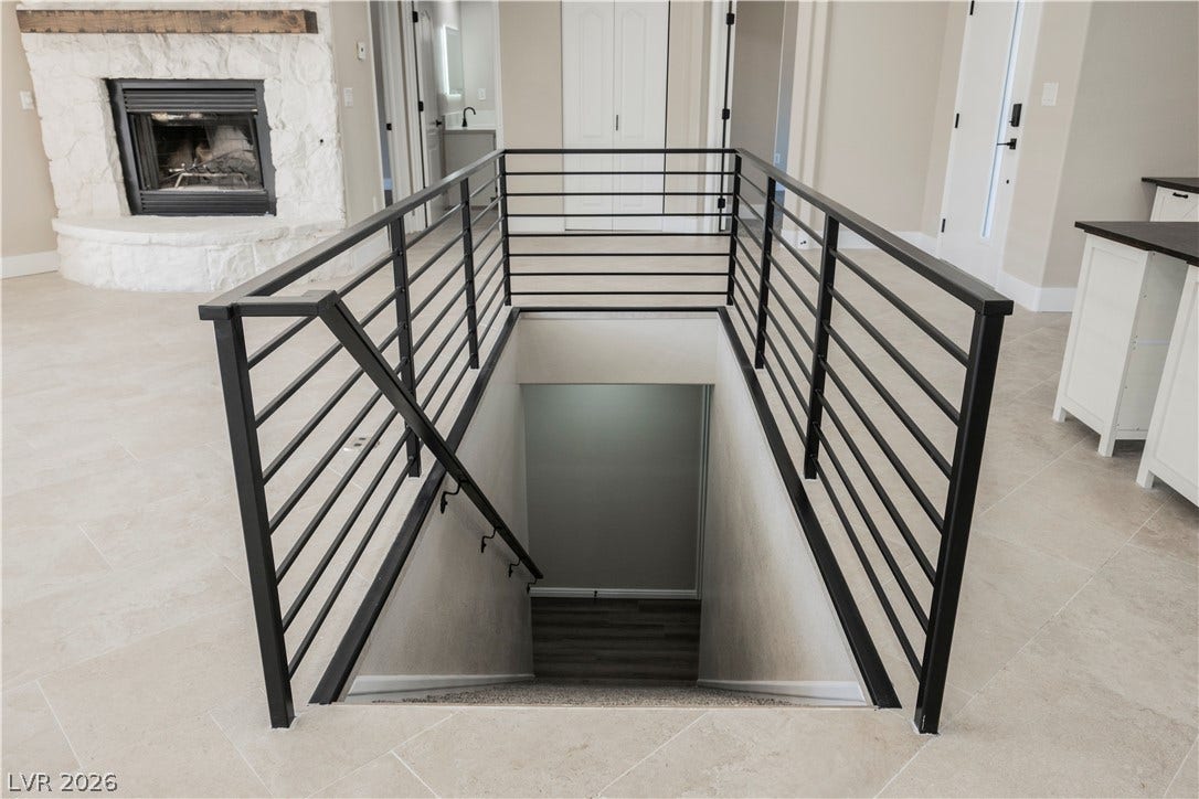 601 Sandy Drive, Henderson, NV 89002 A modern staircase with black metal railings leads to the lower level.