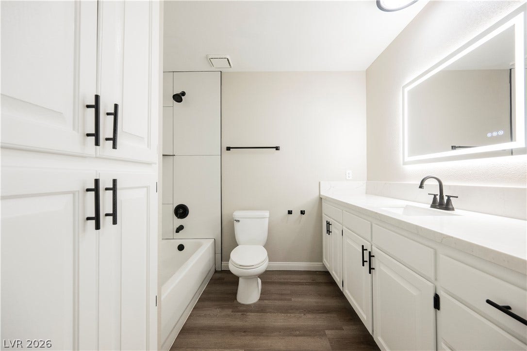 601 Sandy Drive, Henderson, NV 89002 Sleek modern finishes define this bath with a long vanity and clean-lined tub enclosure.