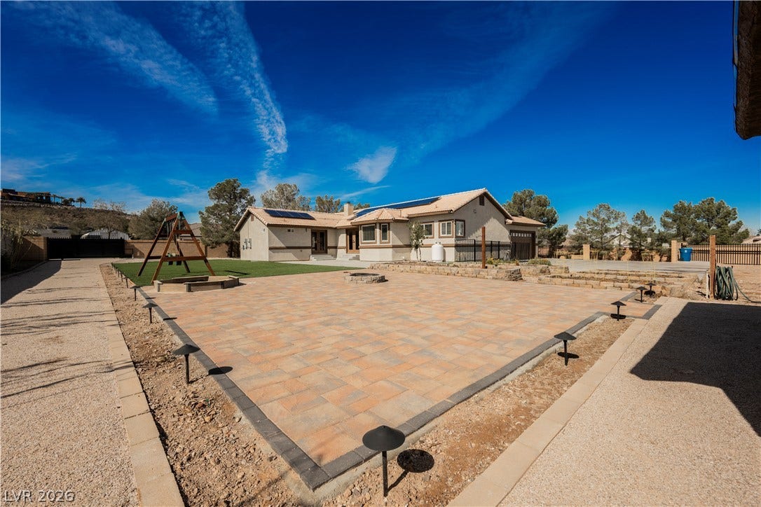 601 Sandy Drive, Henderson, NV 89002 A spacious stone paver patio expands across the backyard under clear desert skies.