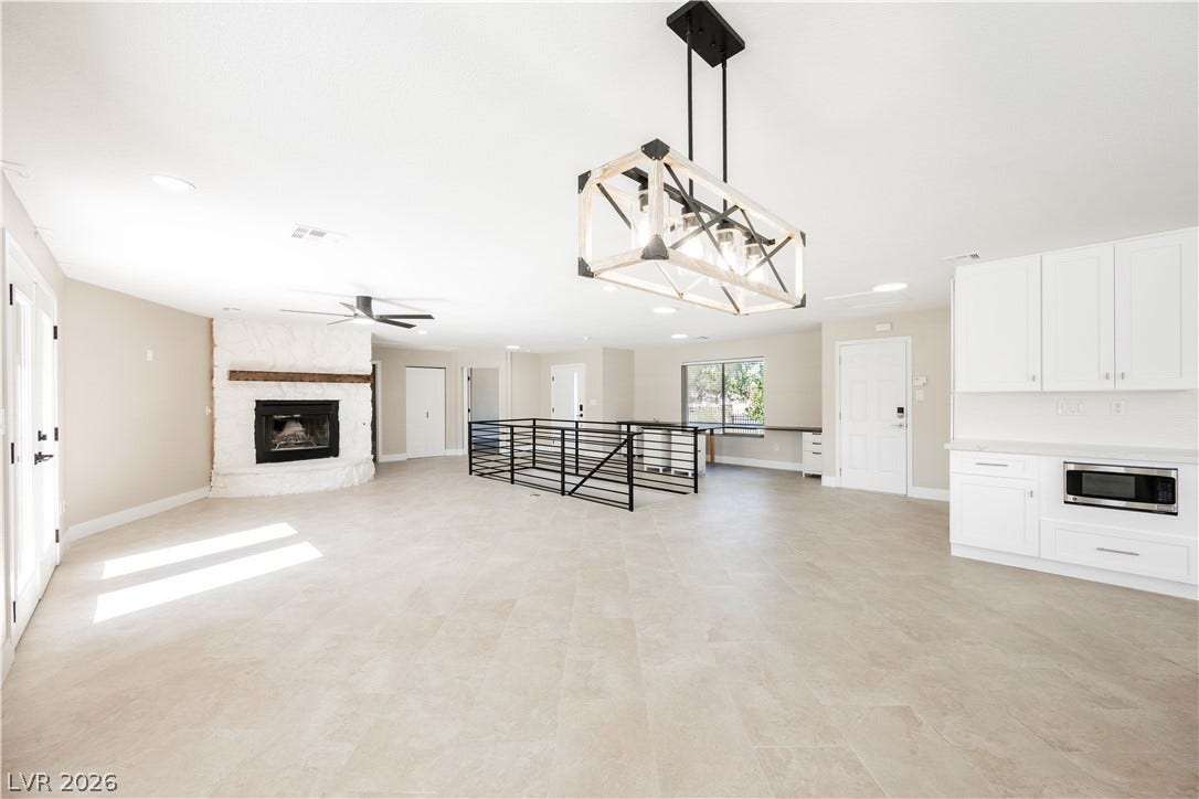 601 Sandy Drive, Henderson, NV 89002 A spacious open-concept interior features neutral tile floors and a classic stone fireplace.