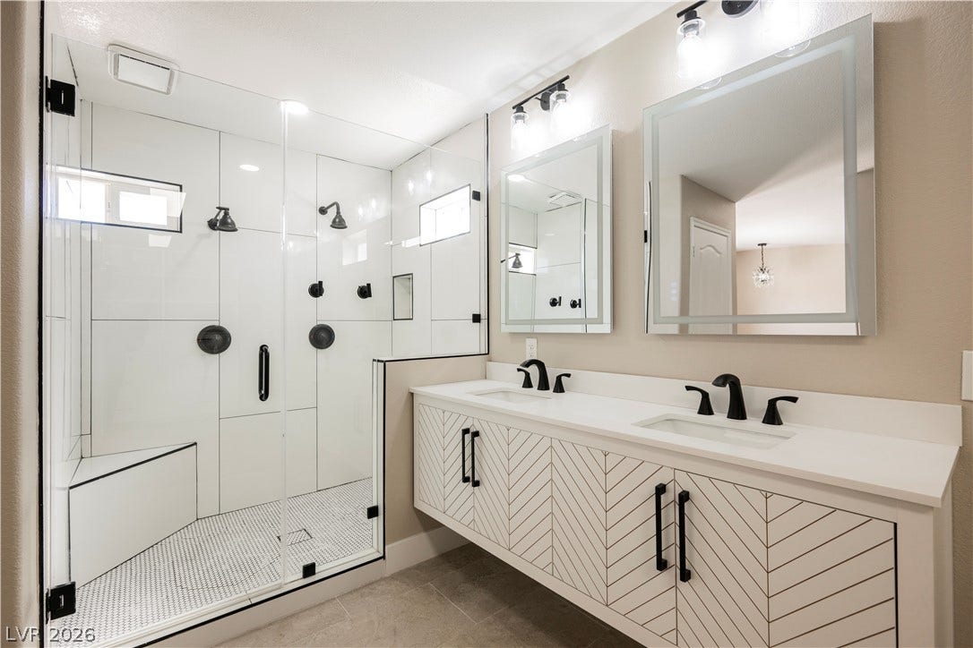 601 Sandy Drive, Henderson, NV 89002 A contemporary dual vanity sits beside an expansive glass-enclosed shower with custom tile work.