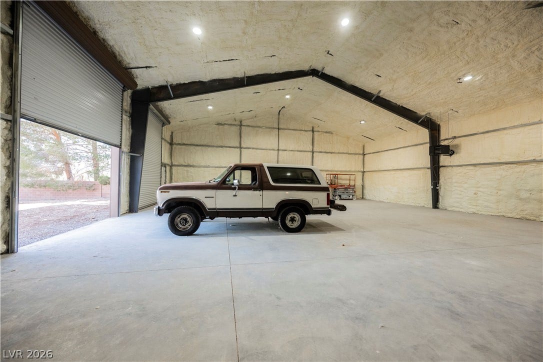 601 Sandy Drive, Henderson, NV 89002 Massive detached outbuilding features durable concrete flooring, insulated walls, and overhead roll-up doors.