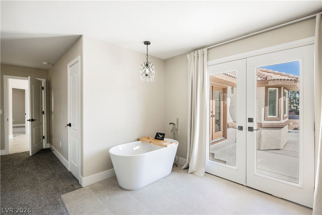 601 Sandy Drive, Henderson, NV 89002 Double glass doors open to the outdoors next to a modern freestanding soaking tub.