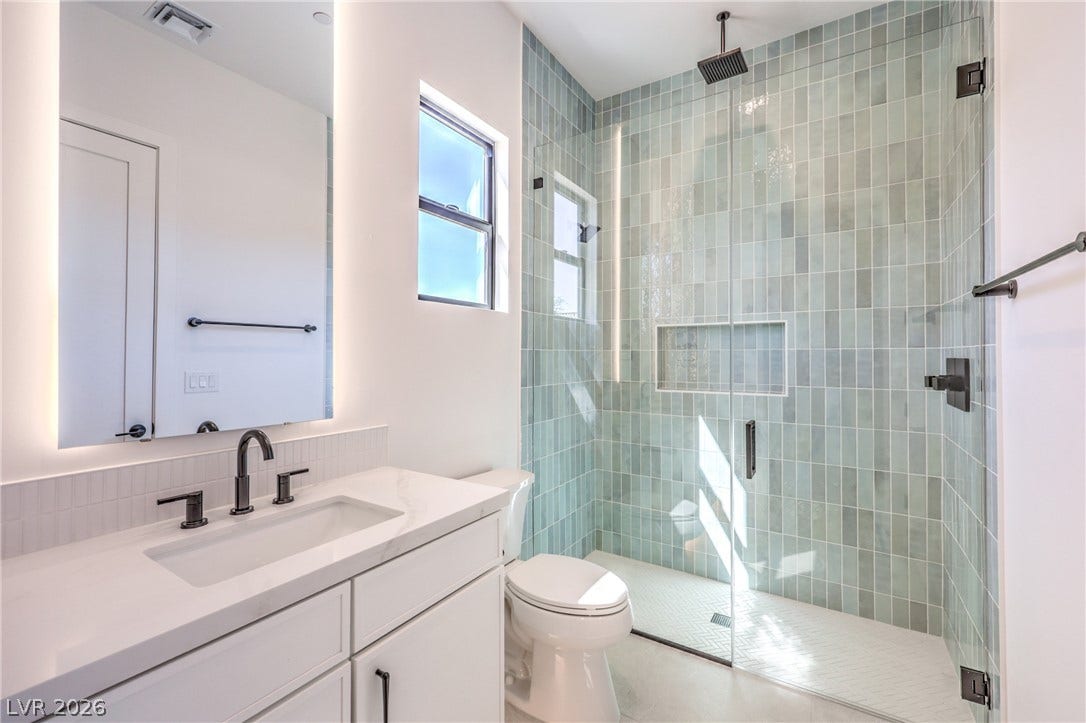 3051 E Serene Avenue, Henderson, NV 89074 Clean lines and vertical tile work define this contemporary bathroom with a walk-in shower.