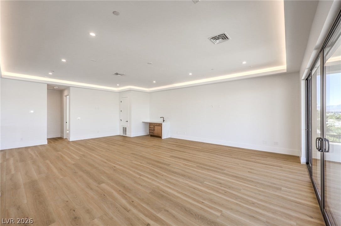 3051 E Serene Avenue, Henderson, NV 89074 Luminous recessed and cove lighting accents this open interior finished with wood floors.