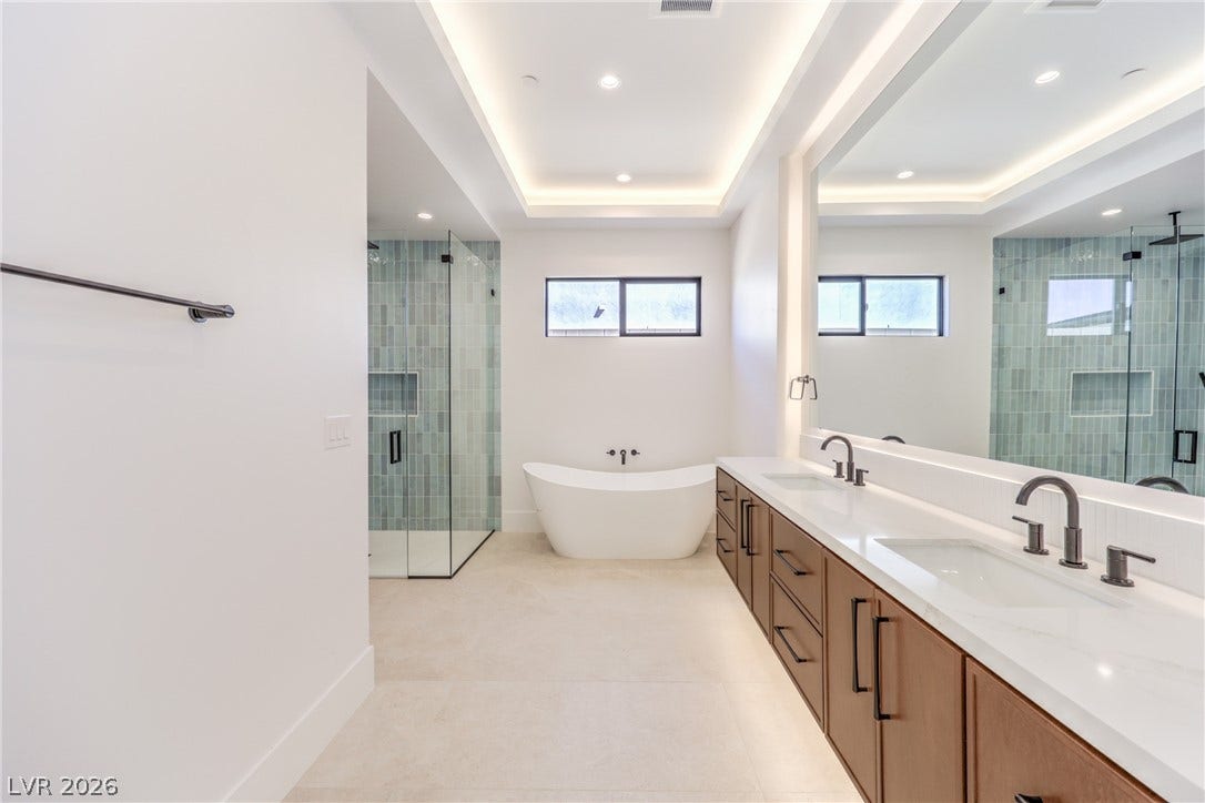 3051 E Serene Avenue, Henderson, NV 89074 Clean lines and a tray ceiling define this modern bath with a glass-enclosed shower.