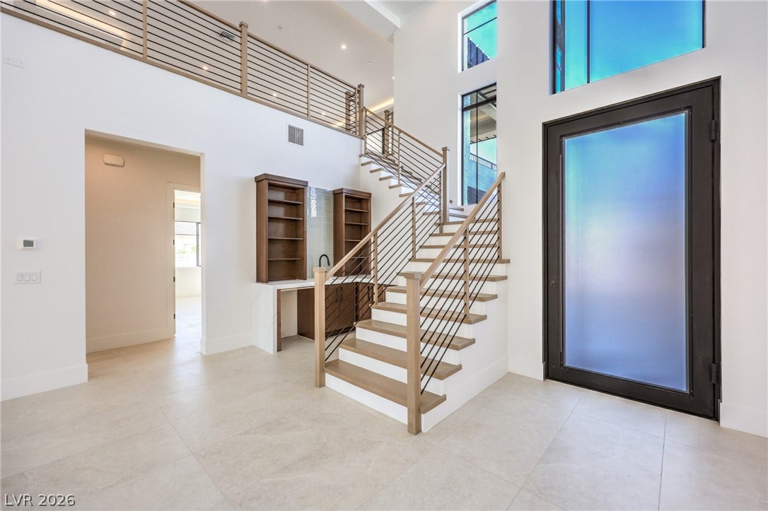 3051 E Serene Avenue, Henderson, NV 89074 Soaring ceilings and an architectural staircase anchor this light-filled entry foyer with tile flooring.