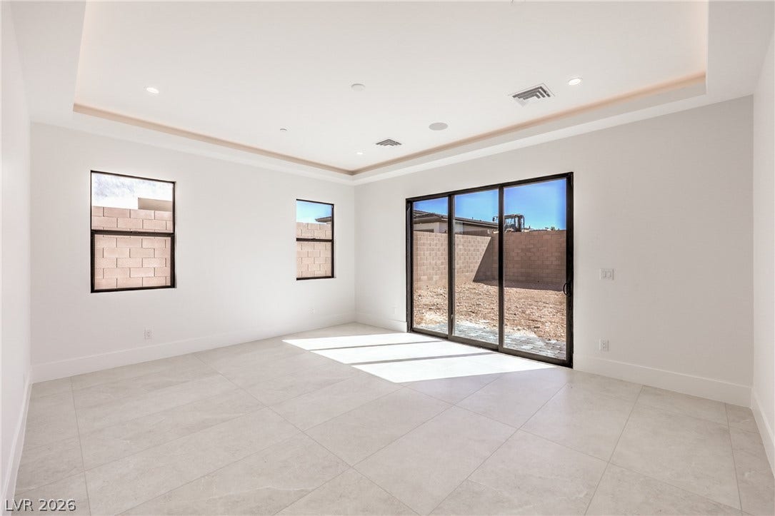 3051 E Serene Avenue, Henderson, NV 89074 Large sliding glass doors open to the backyard from this tile-floored living area.