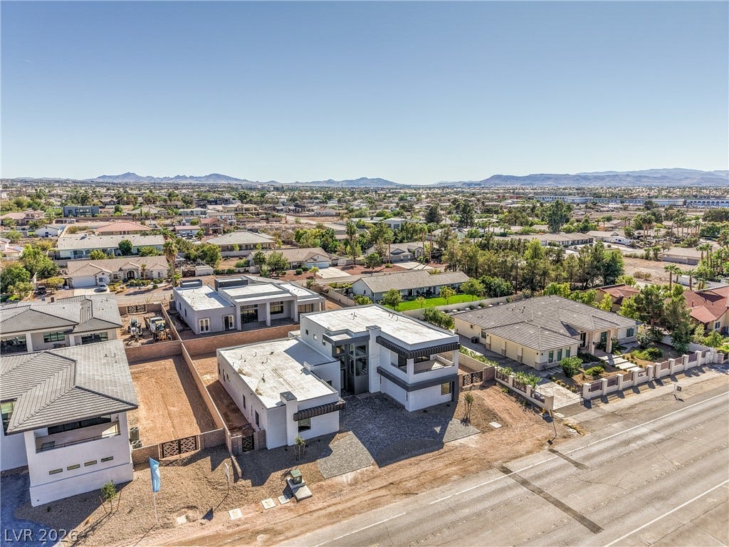 3051 E Serene Avenue, Henderson, NV 89074 An aerial perspective captures contemporary flat-roof architecture set against a sprawling desert mountain backdrop.