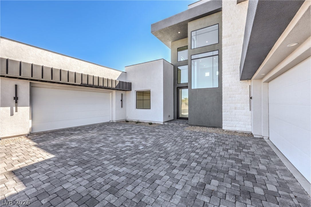 3051 E Serene Avenue, Henderson, NV 89074 Bold contemporary architecture defines this striking entryway featuring geometric lines and towering windows.