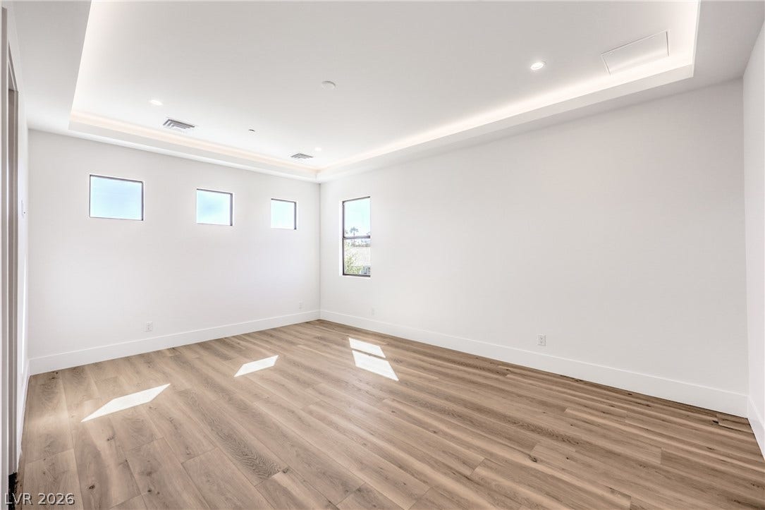 3051 E Serene Avenue, Henderson, NV 89074 Elegant wood-patterned flooring anchors this versatile space featuring a tray ceiling with integrated cove lighting.