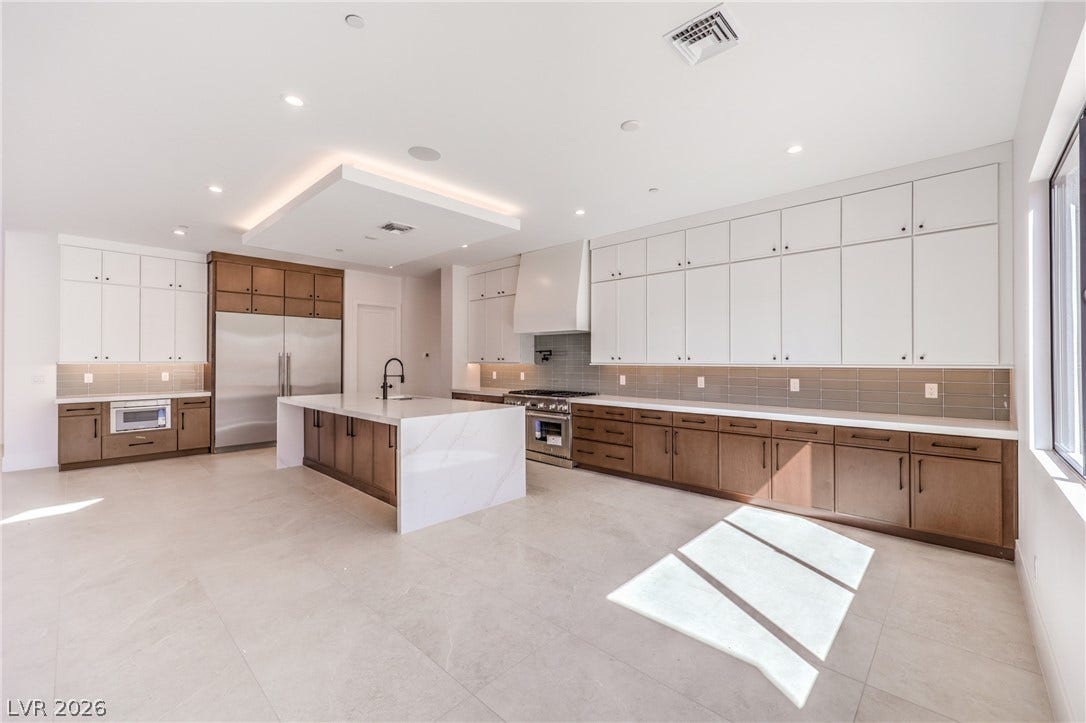 3051 E Serene Avenue, Henderson, NV 89074 An expansive kitchen offers generous custom cabinetry, stone counters, and a central waterfall island.