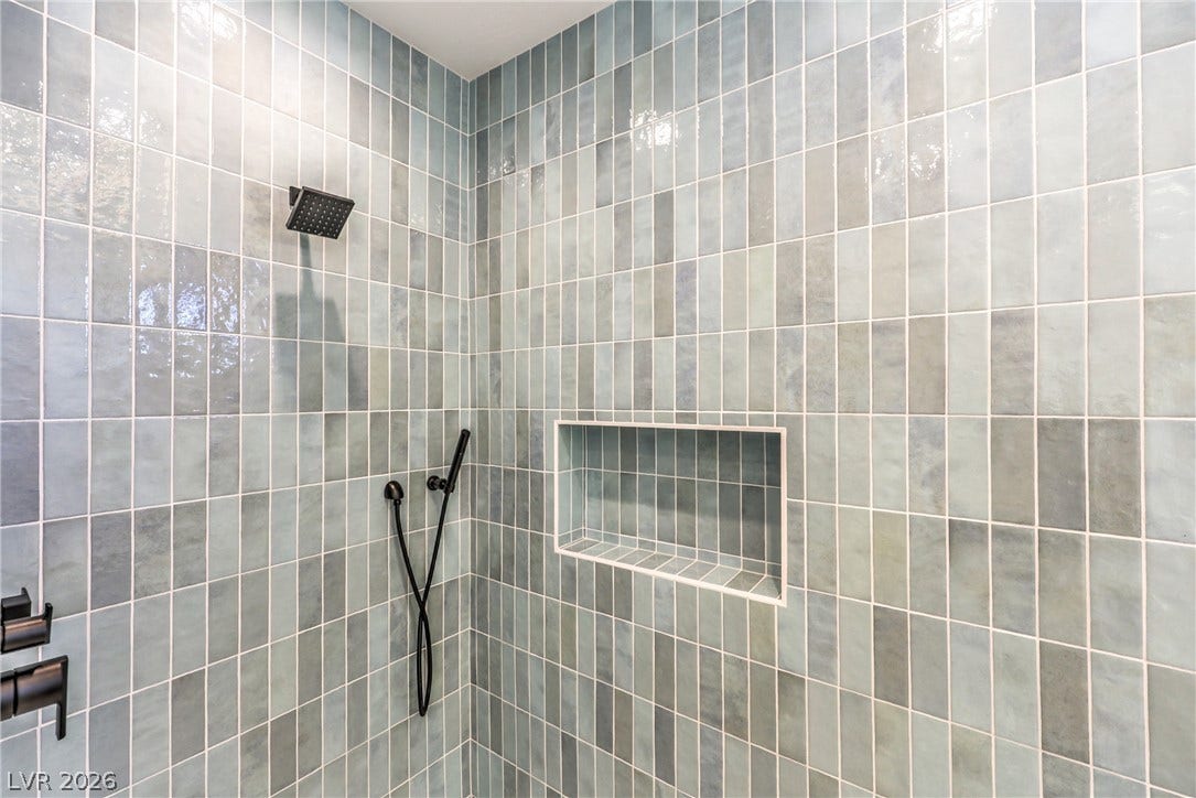 3051 E Serene Avenue, Henderson, NV 89074 Glossy vertical tiles surround this walk-in shower featuring matte black hardware.