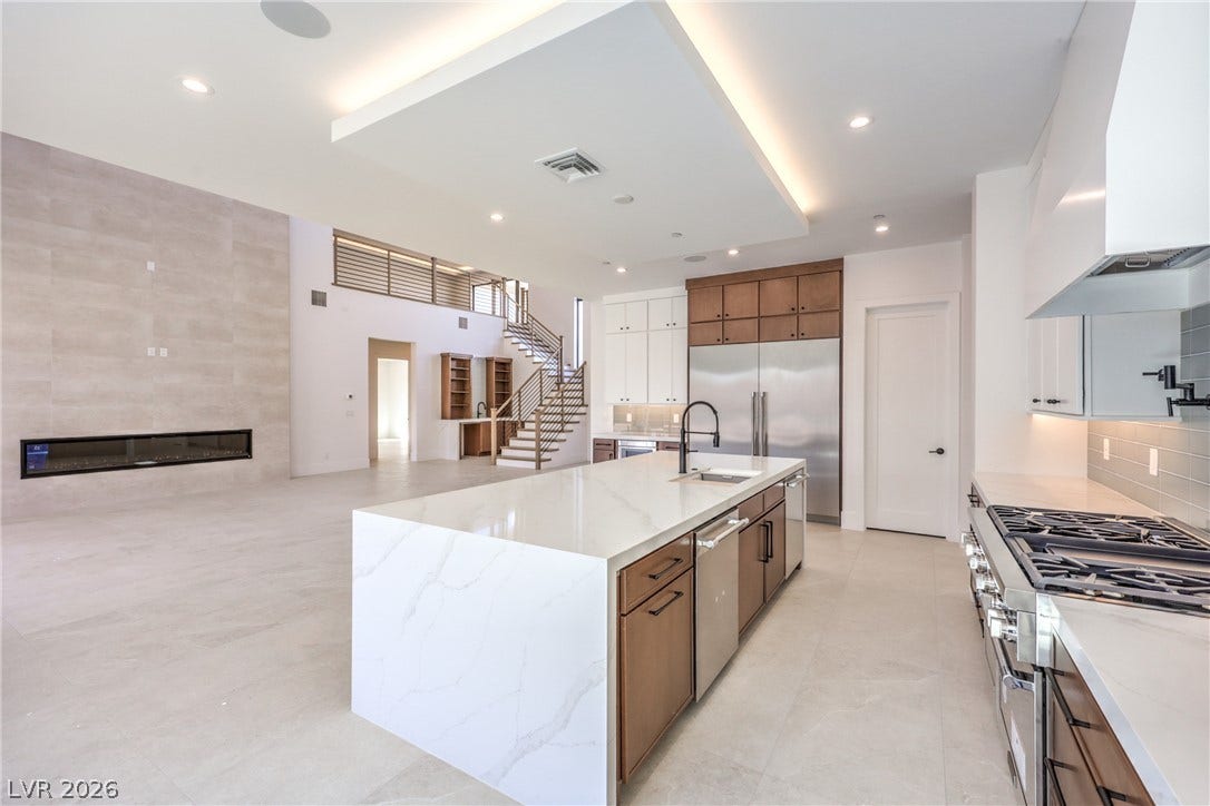 3051 E Serene Avenue, Henderson, NV 89074 An open concept kitchen features a waterfall island and flows into the adjacent living space.