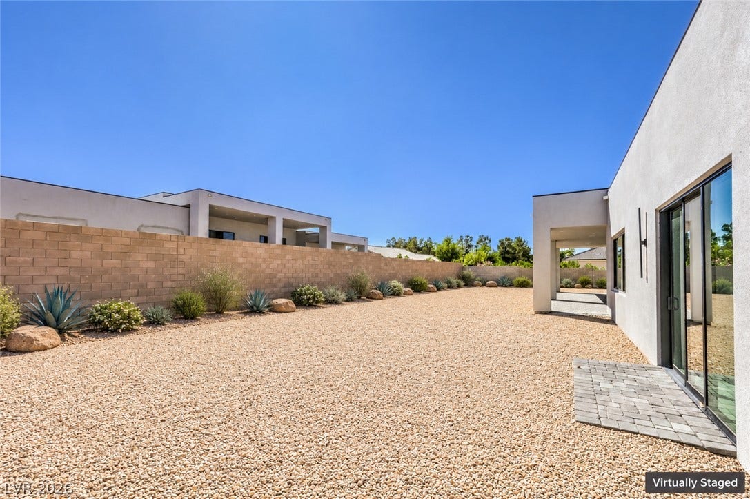 3051 E Serene Avenue, Henderson, NV 89074 Minimalist desert landscaping borders a sleek stucco exterior beneath wide blue skies.