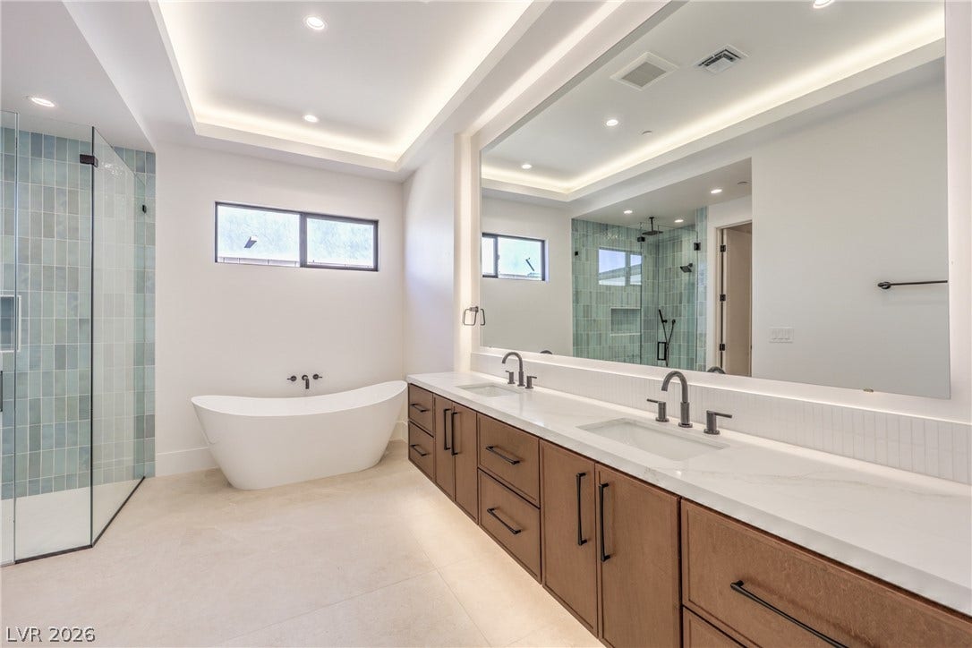 3051 E Serene Avenue, Henderson, NV 89074 Clean lines define this modern bathroom with a freestanding tub and sleek double vanity.