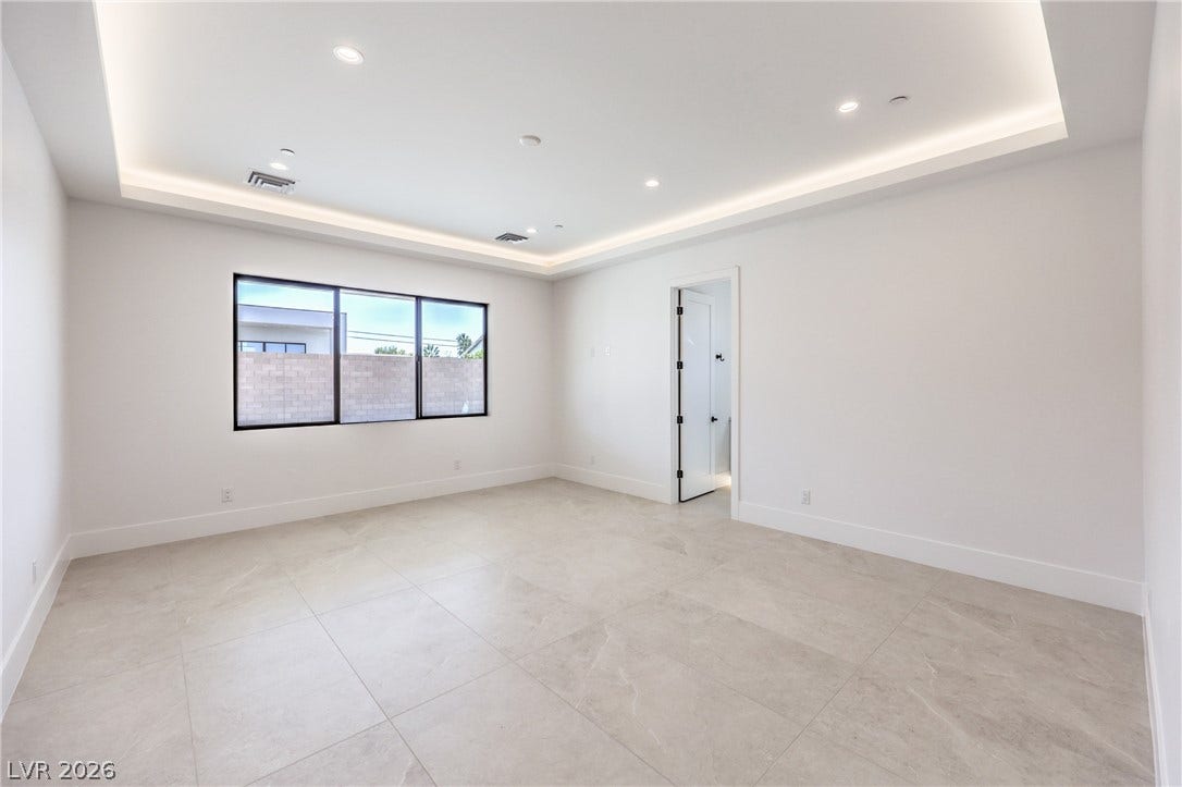 3051 E Serene Avenue, Henderson, NV 89074 Large-format tile floors pair with a tray ceiling and recessed lighting in this open room.
