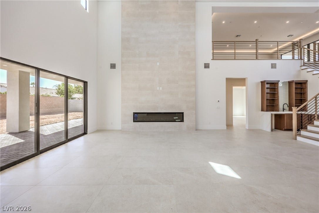 3051 E Serene Avenue, Henderson, NV 89074 Massive ceilings and a floor-to-ceiling fireplace anchor this grand open-concept living space.