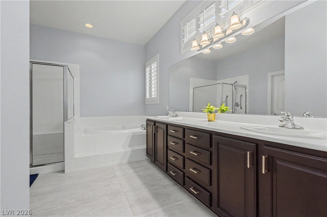 7126 Spindle Berry Street, Las Vegas, NV 89131 Tiled flooring and a spacious vanity with dual sinks define this modern primary bathroom.
