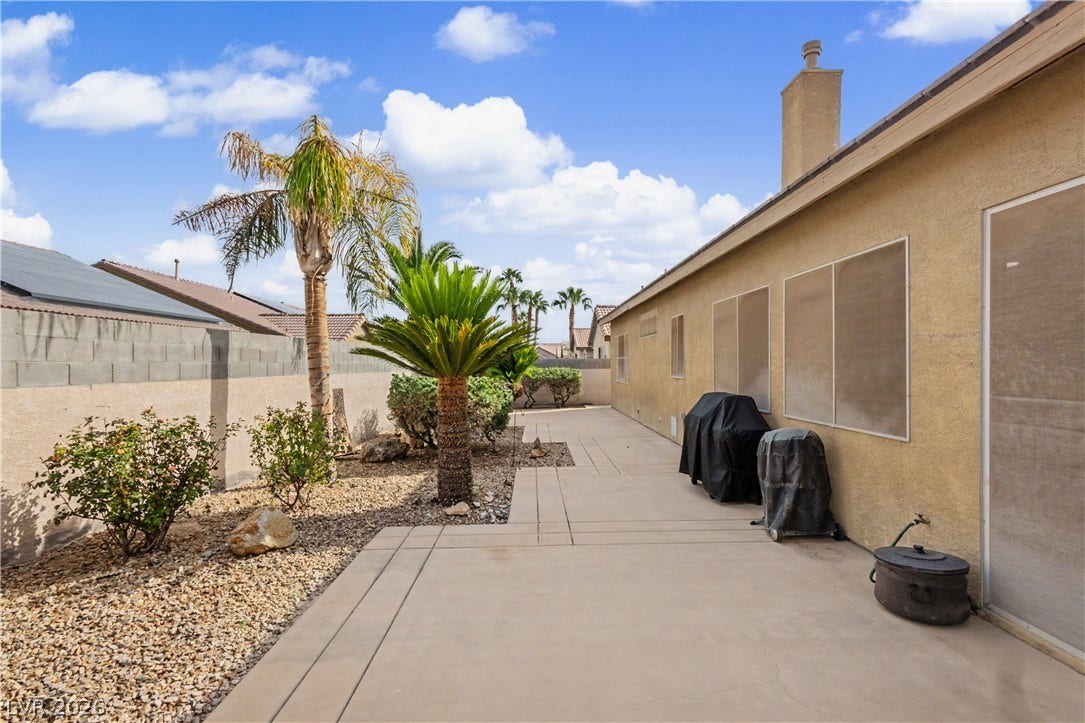 7126 Spindle Berry Street, Las Vegas, NV 89131 An expansive concrete patio runs alongside the home, bordered by low-maintenance desert landscaping.