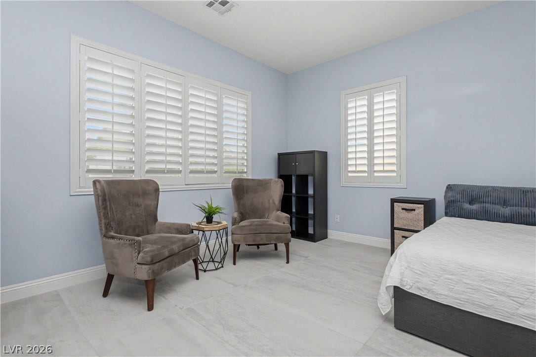 7126 Spindle Berry Street, Las Vegas, NV 89131 Crisp plantation shutters filter natural light across smooth, neutral tile flooring.