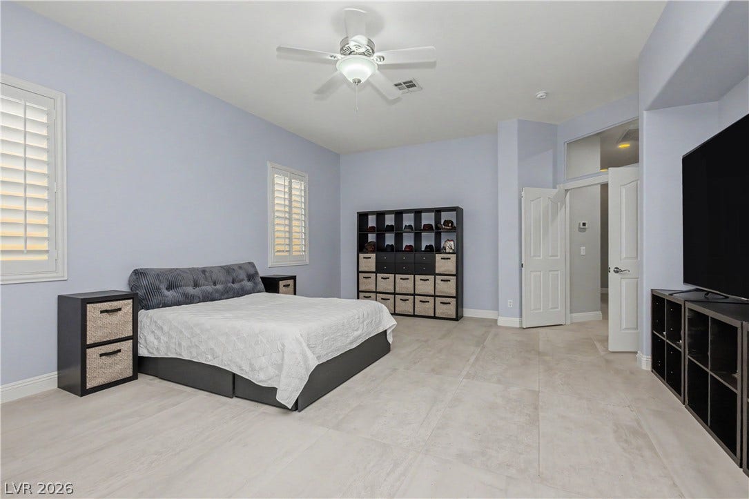 7126 Spindle Berry Street, Las Vegas, NV 89131 High ceilings and clean tile flooring define this spacious primary bedroom retreat.