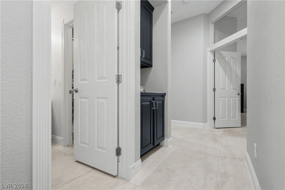 7126 Spindle Berry Street, Las Vegas, NV 89131 Gleaming tile floors and crisp white trim line this central hallway with built-in cabinetry.