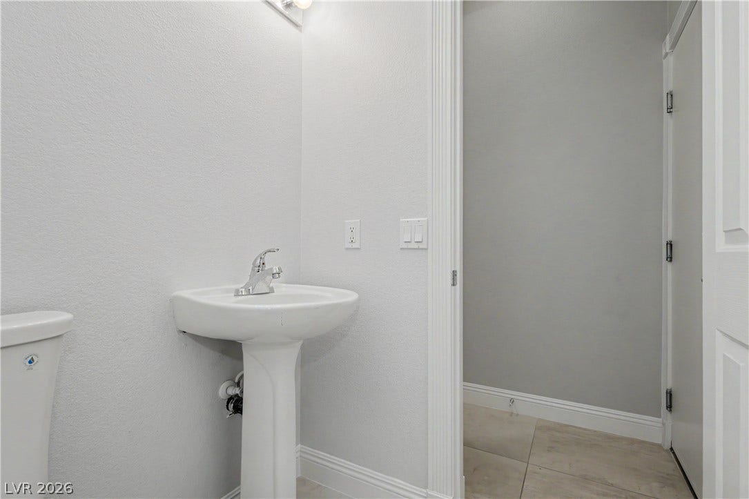 7126 Spindle Berry Street, Las Vegas, NV 89131 Clean lines and classic tile flooring define this functional half bath space.