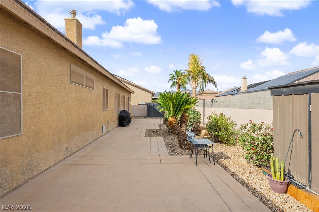 7126 Spindle Berry Street, Las Vegas, NV 89131 A spacious concrete patio borders the low-maintenance desert landscaping in this private side yard.