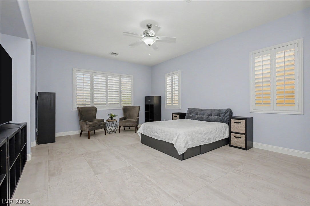 7126 Spindle Berry Street, Las Vegas, NV 89131 Generous windows with plantation shutters fill this spacious bedroom with natural light.