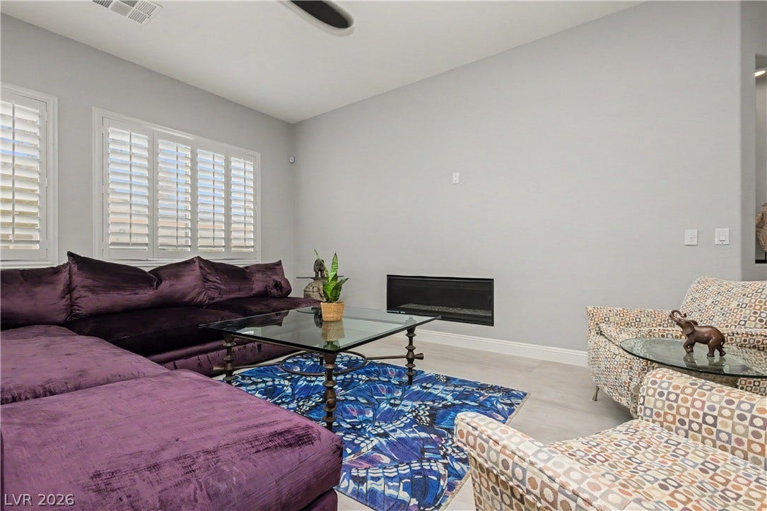 7126 Spindle Berry Street, Las Vegas, NV 89131 An inset modern fireplace highlights this comfortable living area with plantation shutters.