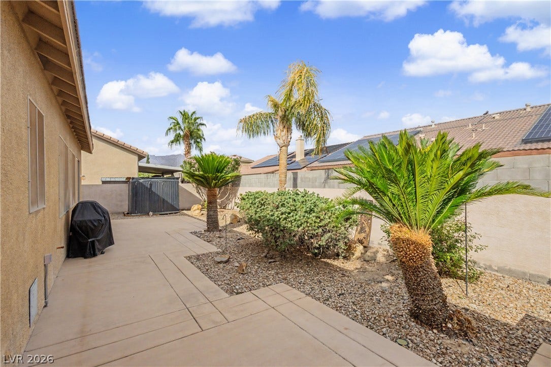 7126 Spindle Berry Street, Las Vegas, NV 89131 Concrete walkways meander through a low-maintenance backyard adorned with desert plantings and tropical palms.