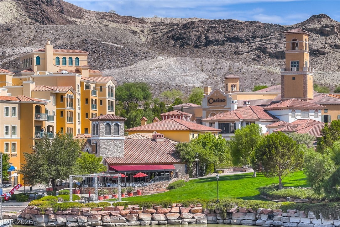 Mediterranean-inspired architecture rises beside manicured lawns and a tranquil stone-lined waterway.