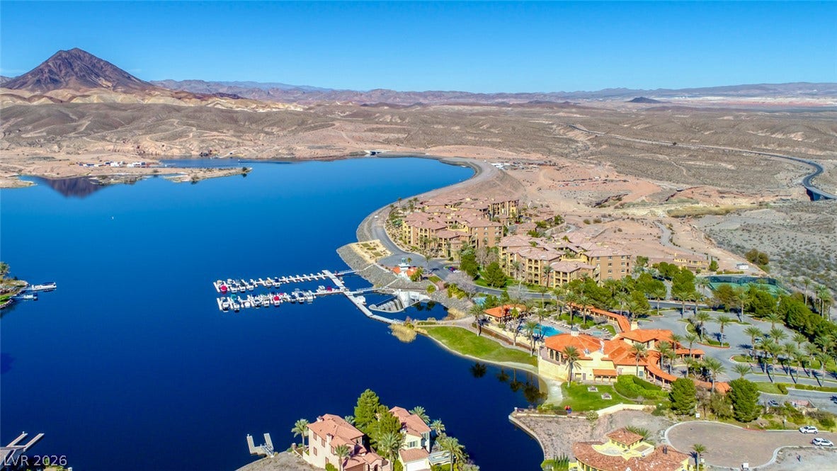 An expansive lakefront community surrounded by dramatic desert mountains and pristine blue waters.