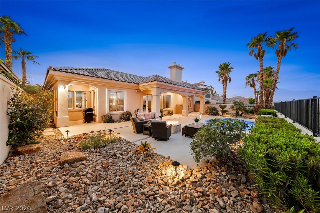 An inviting backyard patio features a sparkling pool and a tiled roof line.