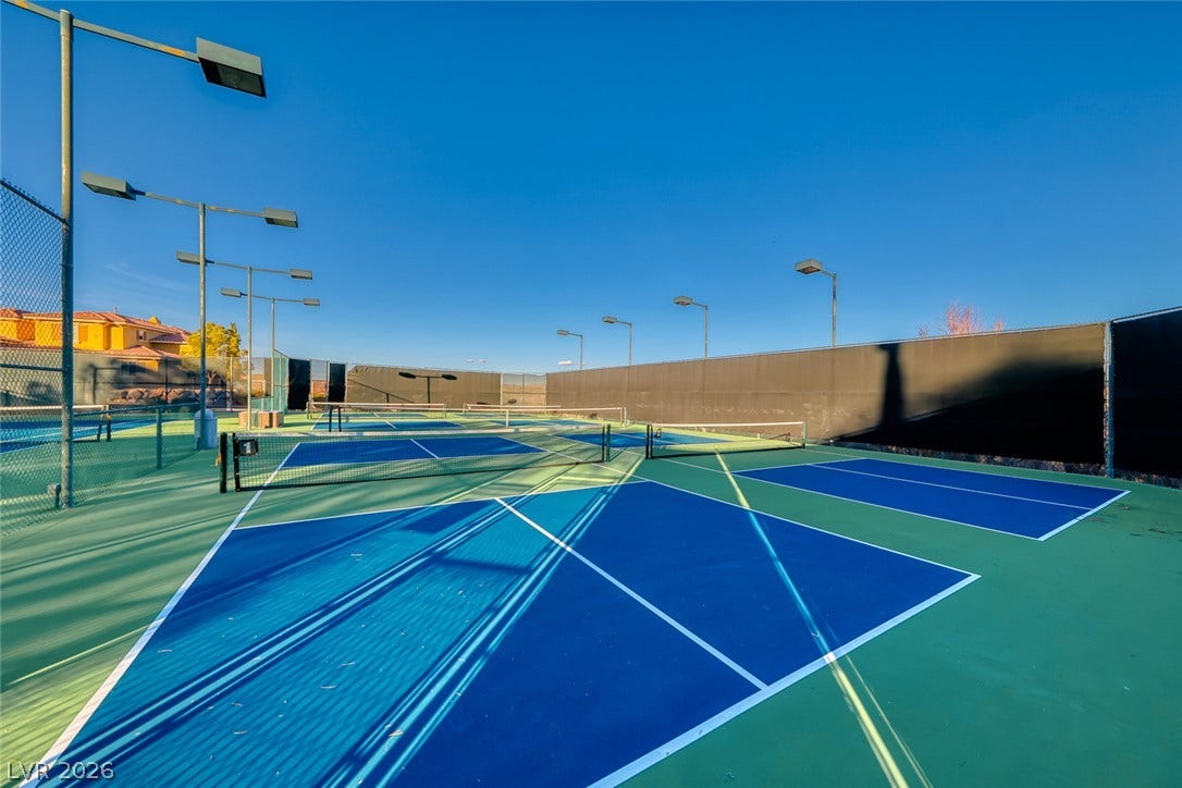 Professional outdoor courts feature vibrant playing surfaces and integrated lighting under clear blue skies.