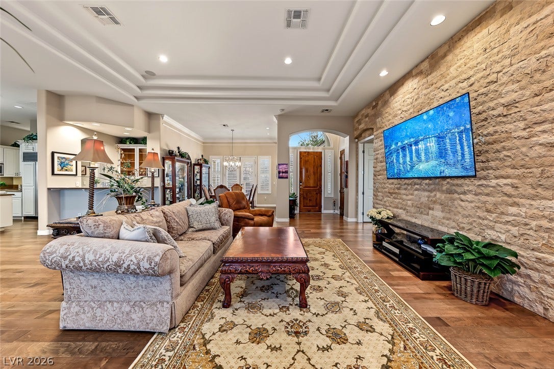 Rich hardwood floors and a textured stone wall create an inviting modern living space.