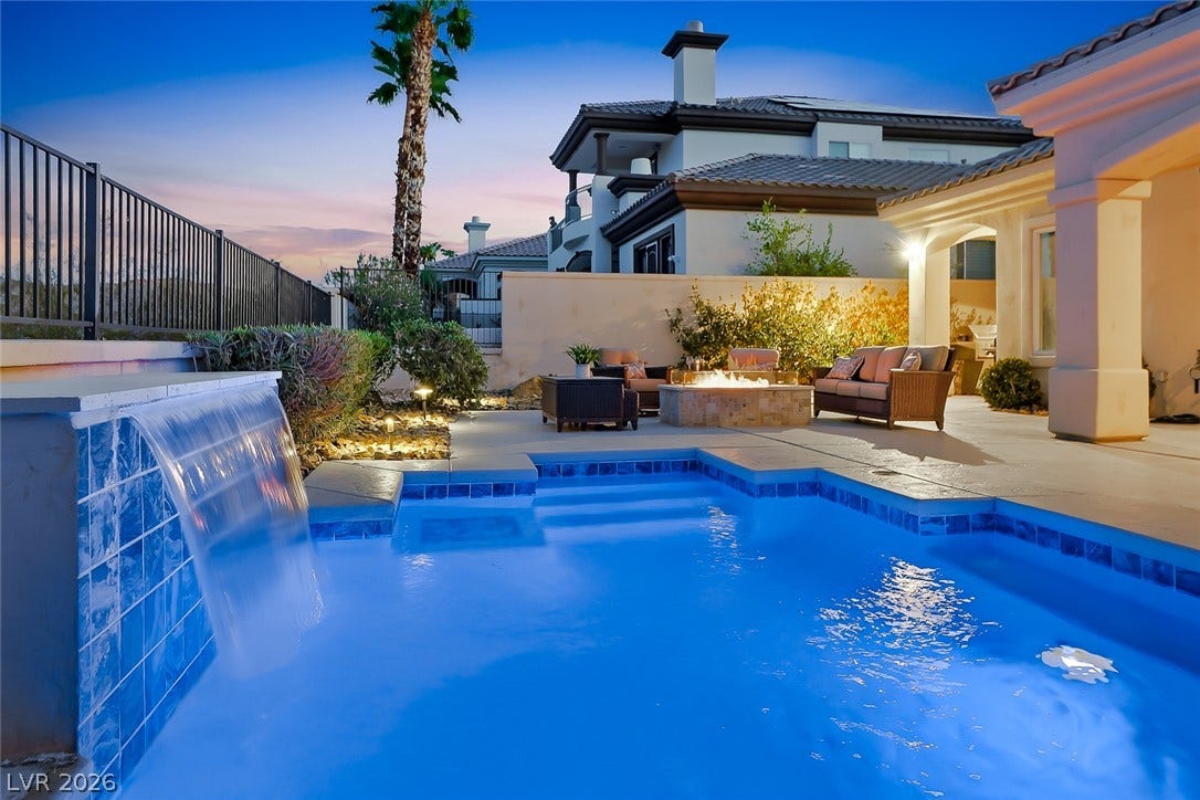 A sparkling pool with a custom water feature highlights the backyard entertaining area.