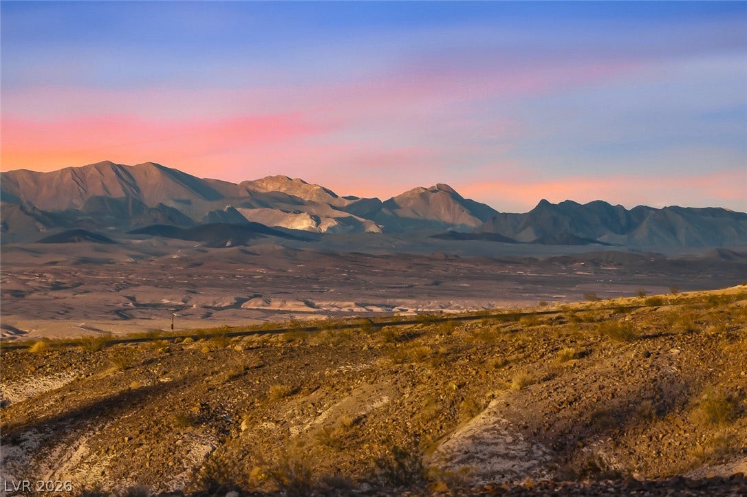 Sweeping desert vistas and rugged ridgelines unfold beneath a dramatic twilight sky.