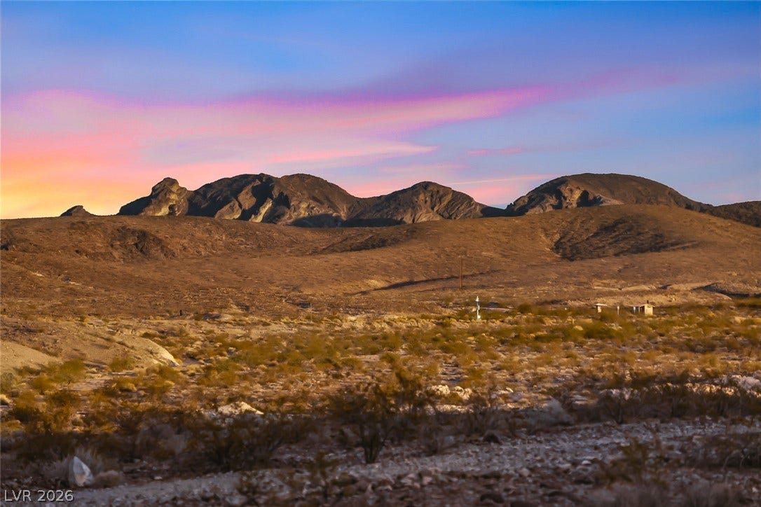 Rugged ridges define the horizon under a colorful sky.