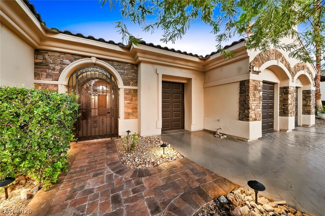 Exquisite stone accents and a gated entry archway elevate this elegant exterior facade.
