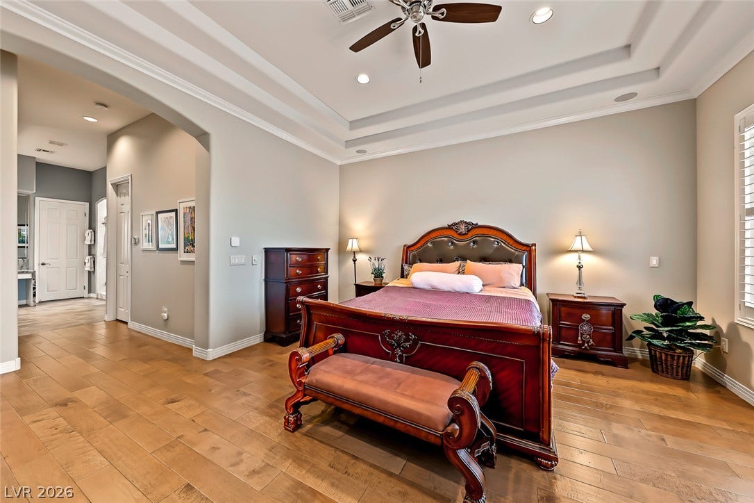 Rich hardwood floors complement the elegant tray ceiling details in this bedroom suite.