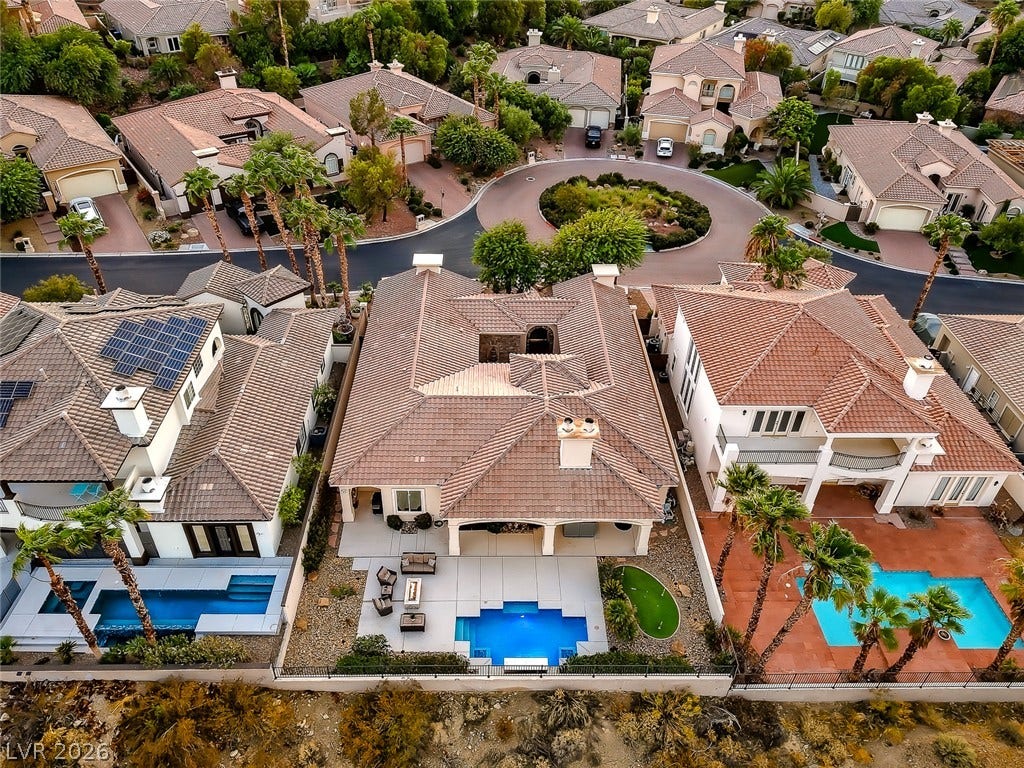 An aerial perspective showcases the classic barrel tile rooflines and inviting backyard swimming pools.