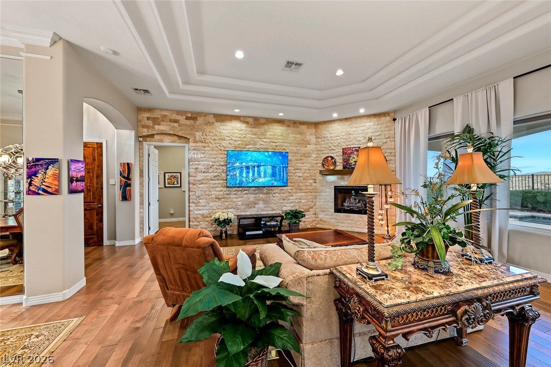 Gleaming hardwood floors and a stacked stone fireplace wall define this inviting living space.