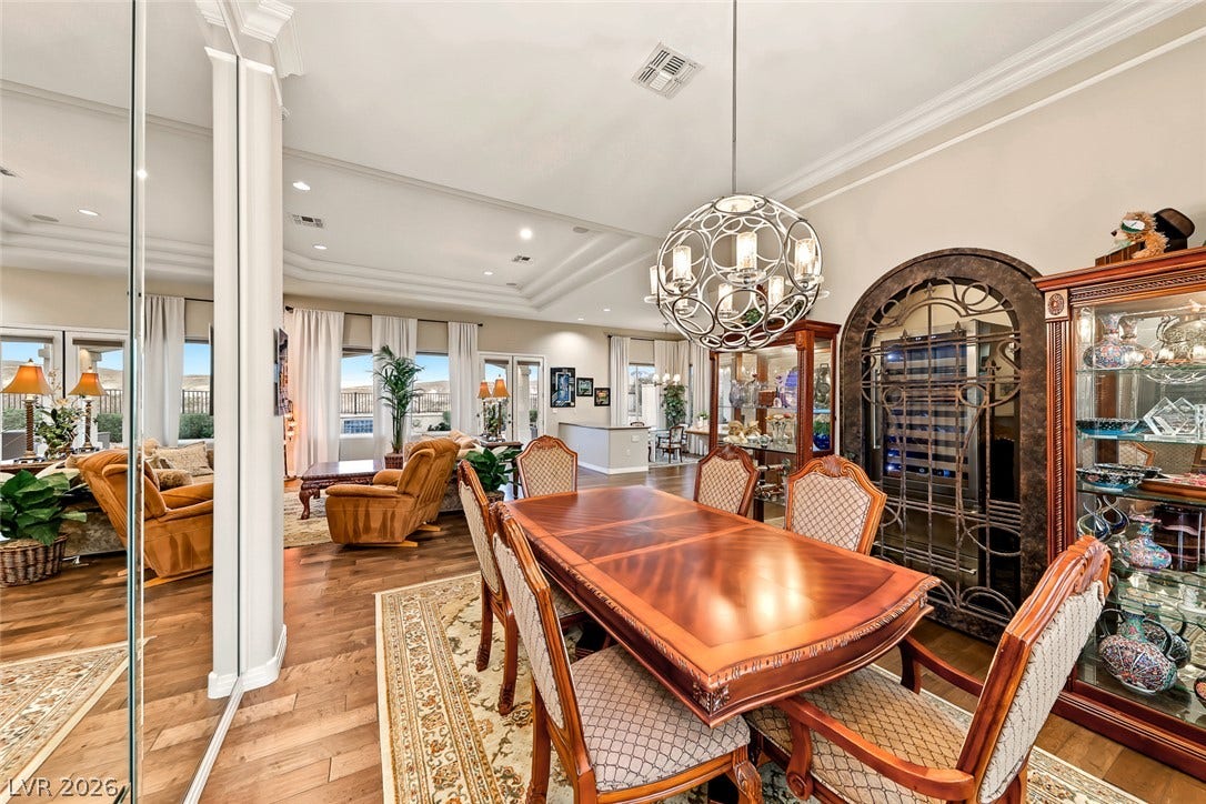 Gleaming hardwood floors and a tray ceiling define this open-concept dining space.