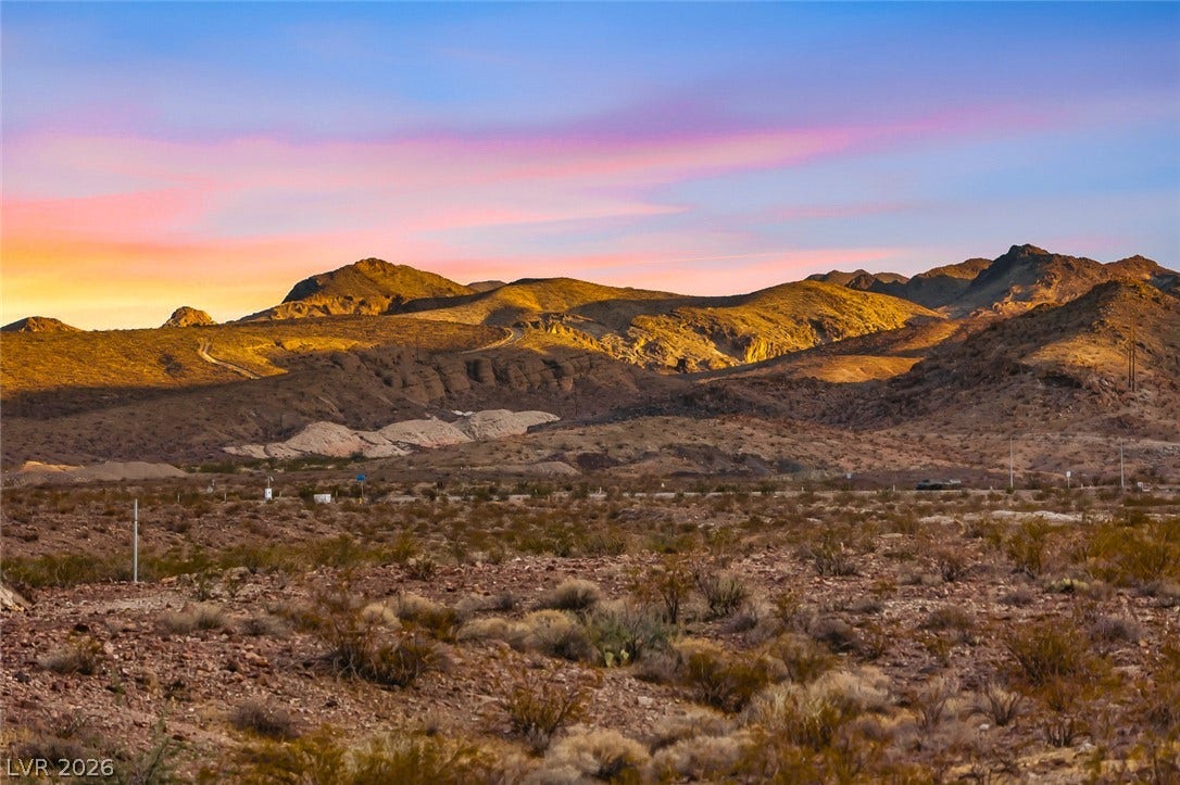 Dramatic mountain ranges frame the vast desert horizon under a twilight sky.