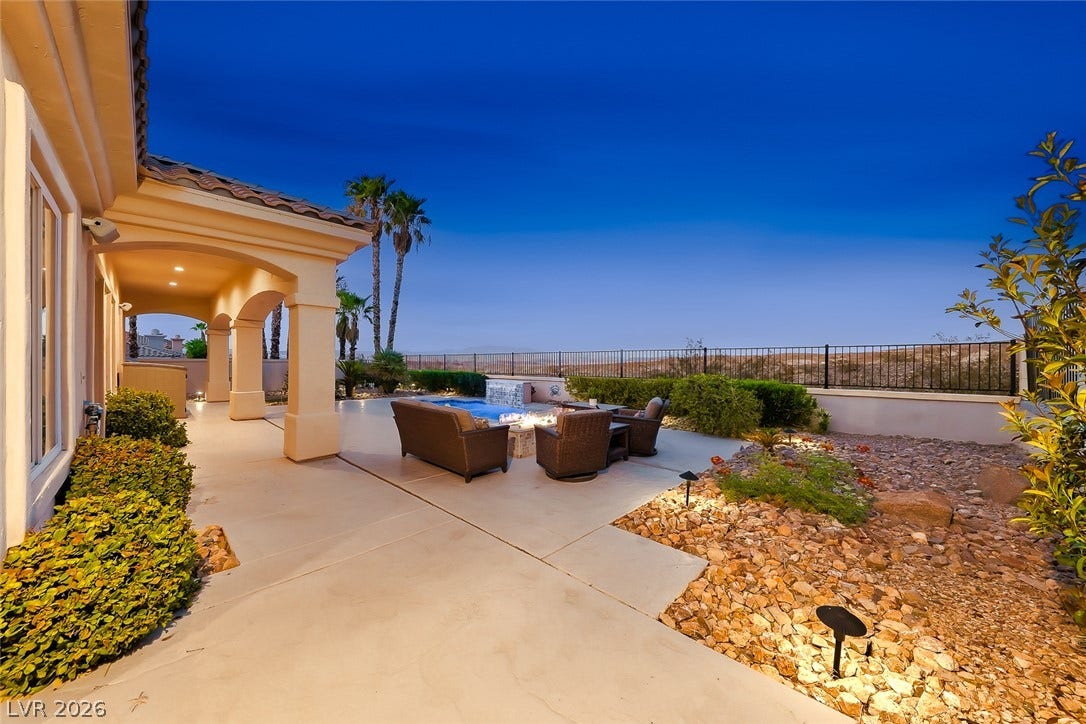 A spacious concrete patio offers sweeping views of the surrounding hills under evening skies.