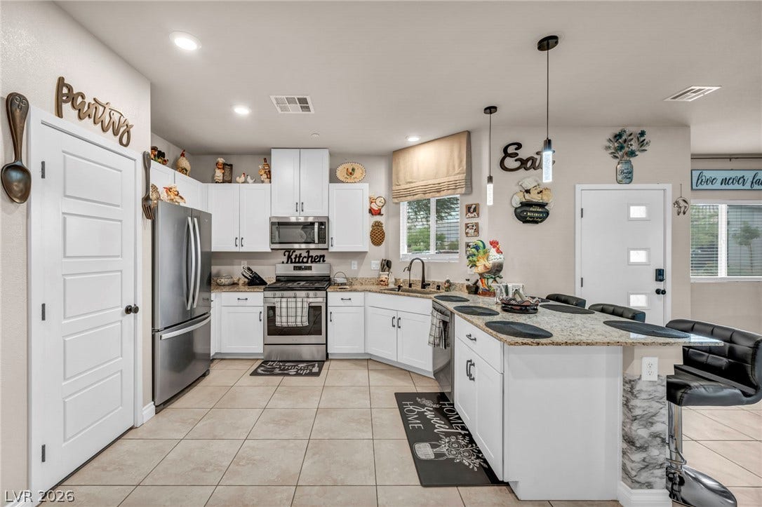 7481 Garnet Moon Street, North Las Vegas, NV 89084 Gleaming tile floors and granite countertops define this modern culinary workspace.