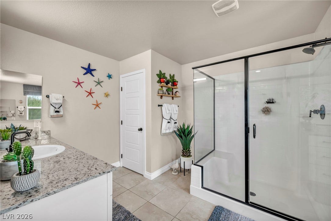 7481 Garnet Moon Street, North Las Vegas, NV 89084 A spacious walk-in shower with glass doors sits adjacent to a granite-topped vanity.