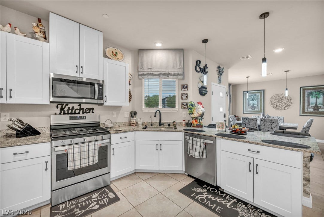 7481 Garnet Moon Street, North Las Vegas, NV 89084 White cabinetry, stone countertops, and an open layout define this airy culinary space.